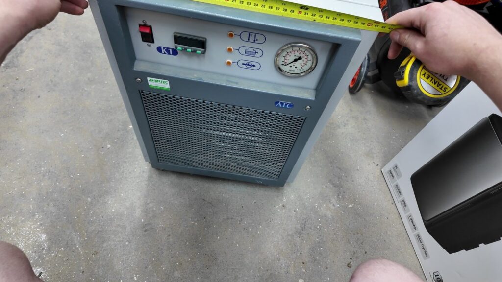 Measuring the laser chiller with a tape measure before designing its shipping crate